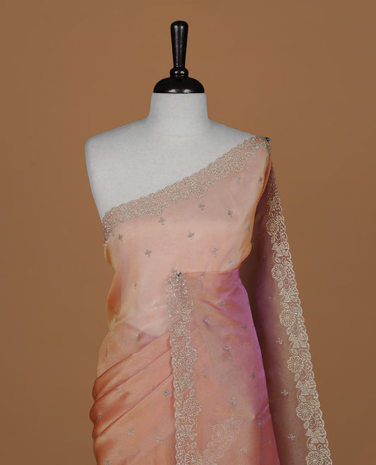 Pinkish orange colour designer saree featuring stone worked body, stone worked border, paired with matching blouse piece.