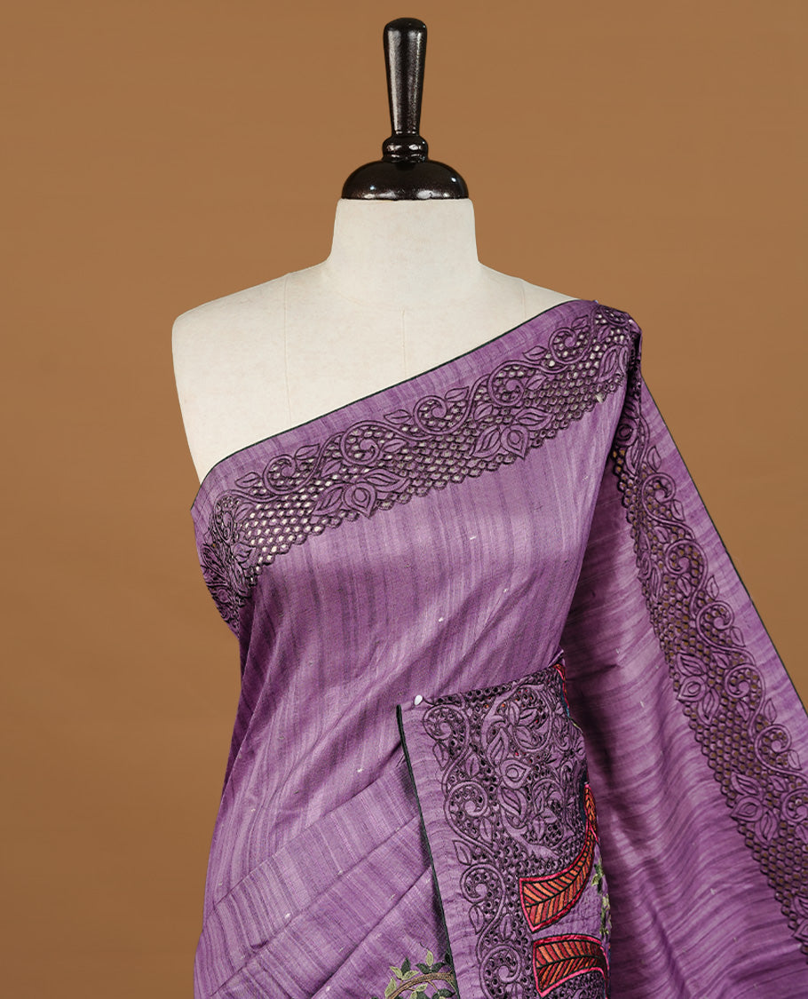 Purple colour Semi Tussar silk saree features an intricate cutwork embroidered peacock motifs on border, paired with a matching unstitched blouse piece.