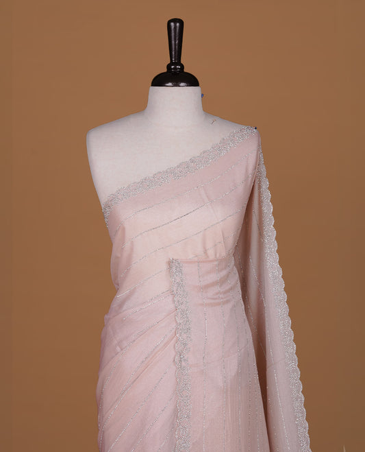 Light Peach colour designer saree featuring white stone stripes on body, highlighting white stone with scalp border, paired with matching blouse piece.