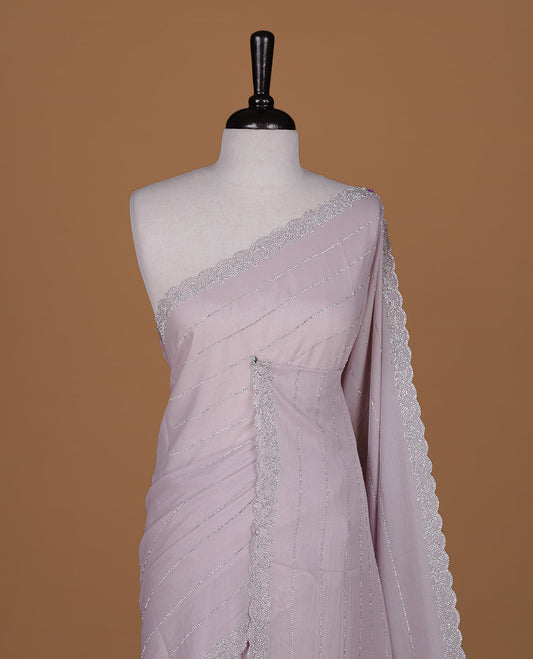 Light pink colour designer saree featuring white stone stripes on body, highlighting white stone with scalp border, paired with matching blouse piece.