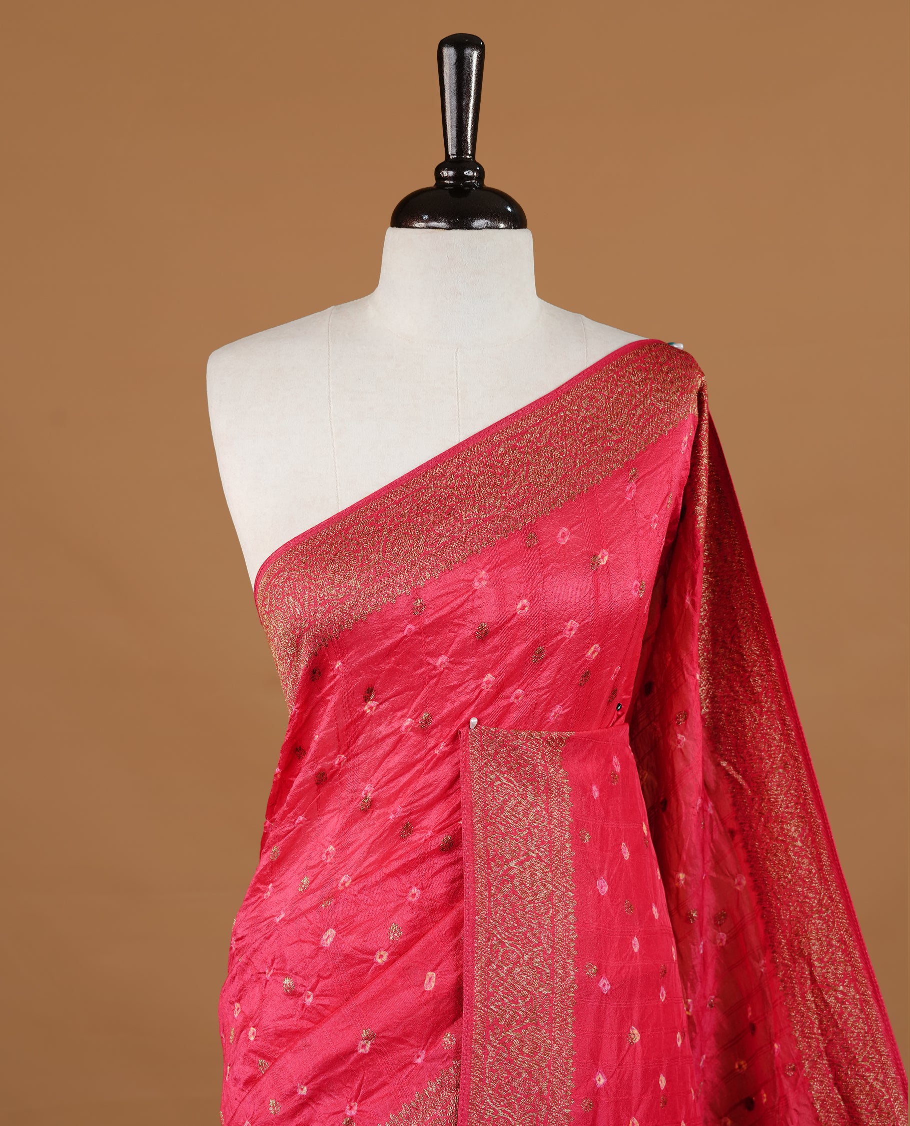 Red colour Banarasi Bandhani silk saree featuring intricate antique zari circle Buttas across the body, complemented by an elegant antique zari border. Comes paired with a matching blouse piece
