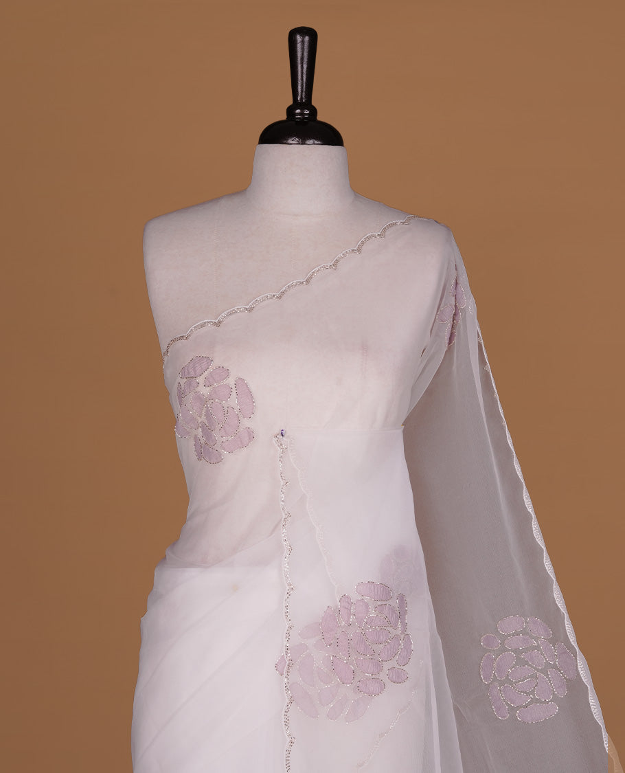White colour net orange saree featuring pastel purple floral pattern with cut beats on body, highlighting scalp border, paired with matching blouse piece.