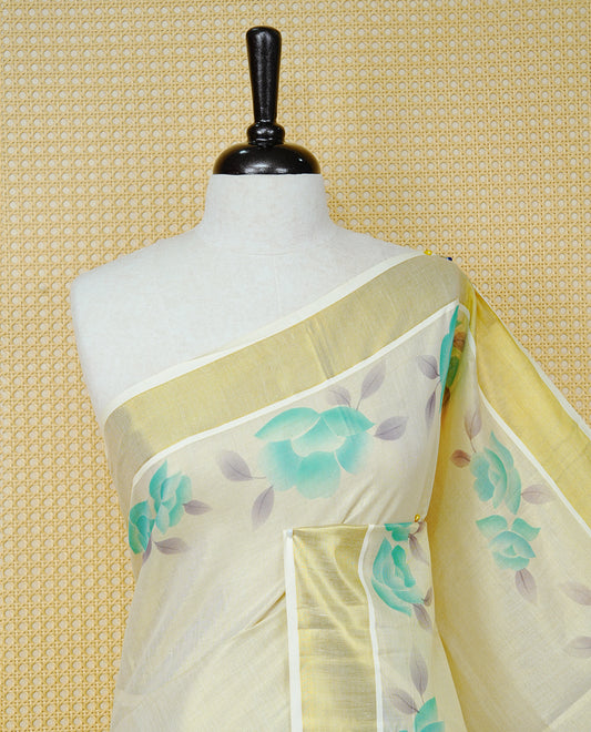 Cream Colour Tissue Kerala Saree Featuring Digital  Mind Rose Prints Across The Body, Enhanced With A Gold Zari Border , Finished With Mind & Cream Tassels And A Matching Blouse Piece