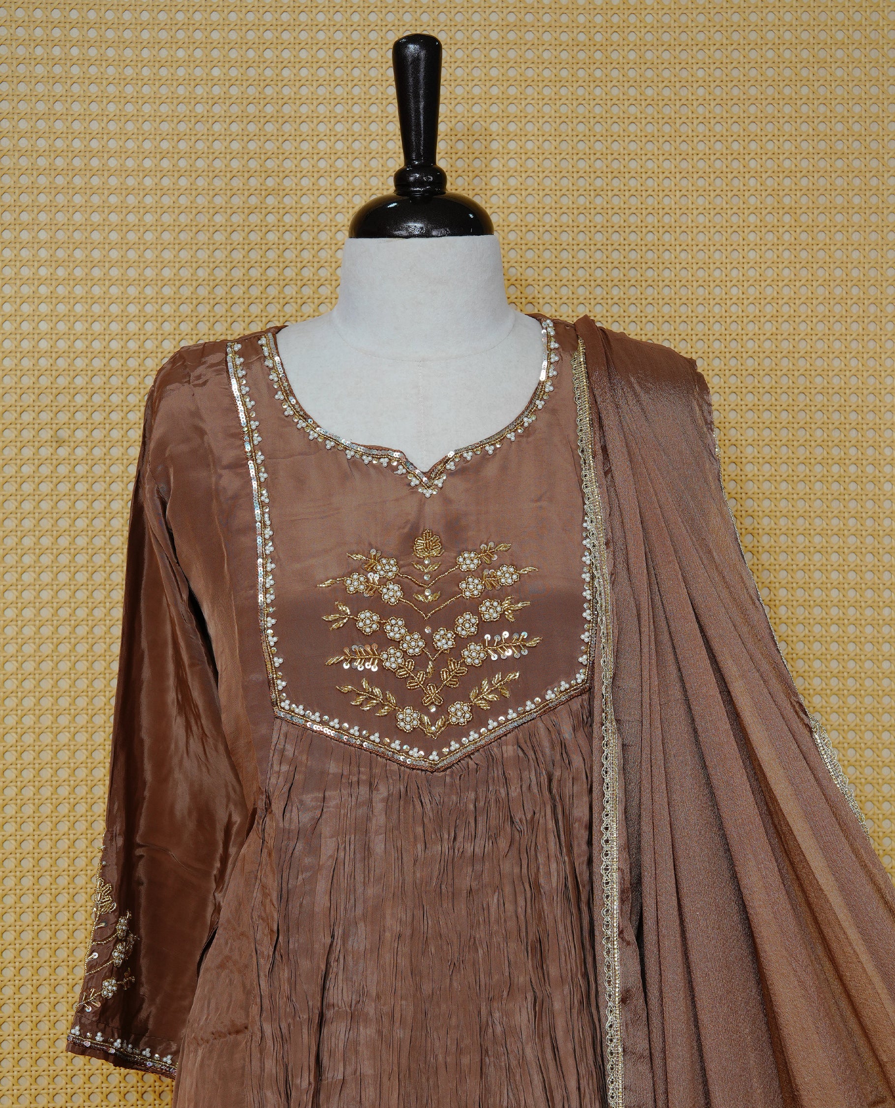 Pastel brown colour churidar set with bead and sequin floral embroidery on the yoke, a delicately embellished neckline and sleeve cuffs, paired with a matching bordered dupatta and solid pants.