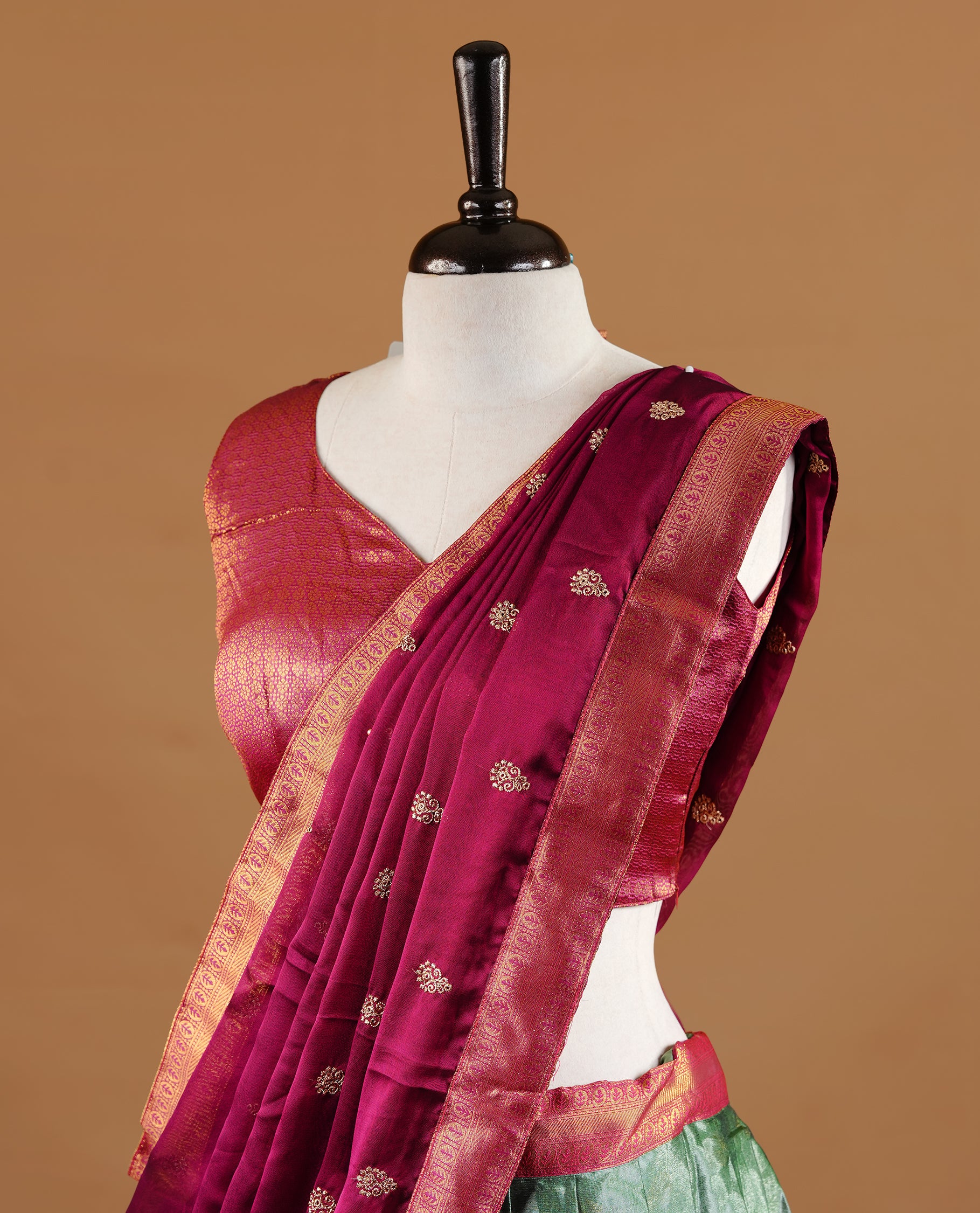 Green colour Half saree featuring green colour skirt with contrast magenta colour traditional border, paired with matching stitched blouse, matching dupatta.