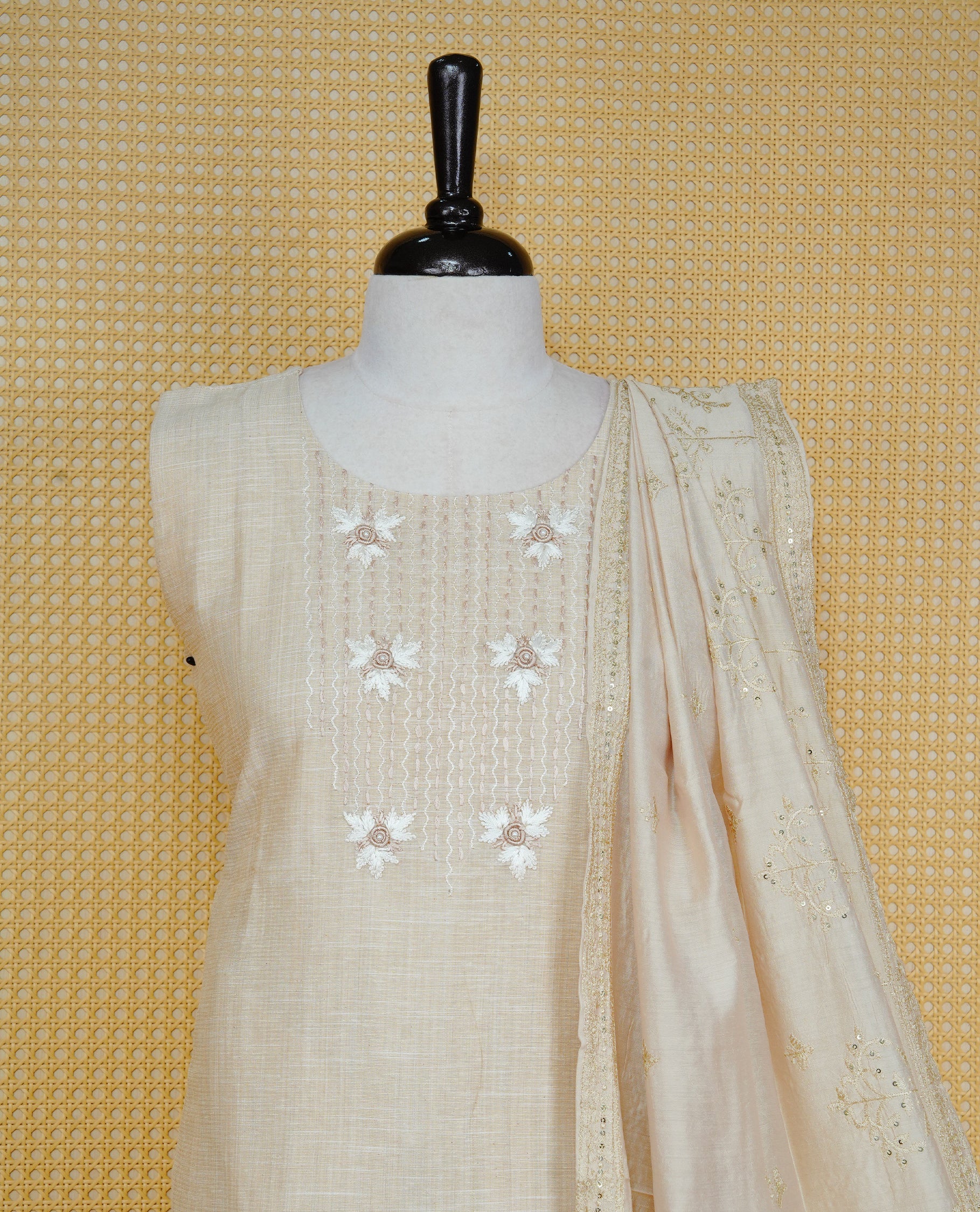 Beige colour churidar set featuring delicate floral embroidery on the yoke, paired with matching solid pants and an embroidered dupatta