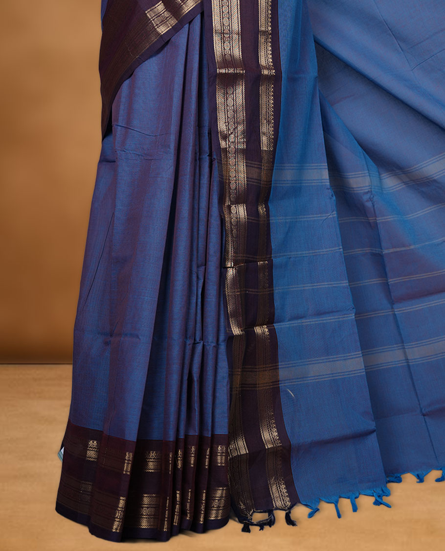 Blue colour chettinad cotton saree featuring Elegant body, contrast purple colour border with gold zari border, pallu and paired with matching blouse.