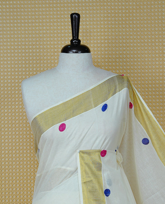 Cream Colour cotton Kerala Saree Featuring  Magenta & Blue Dot Prints On The Body, Complemented By A Traditional Gold Zari Border, Paired With A Matching Blouse Piece.