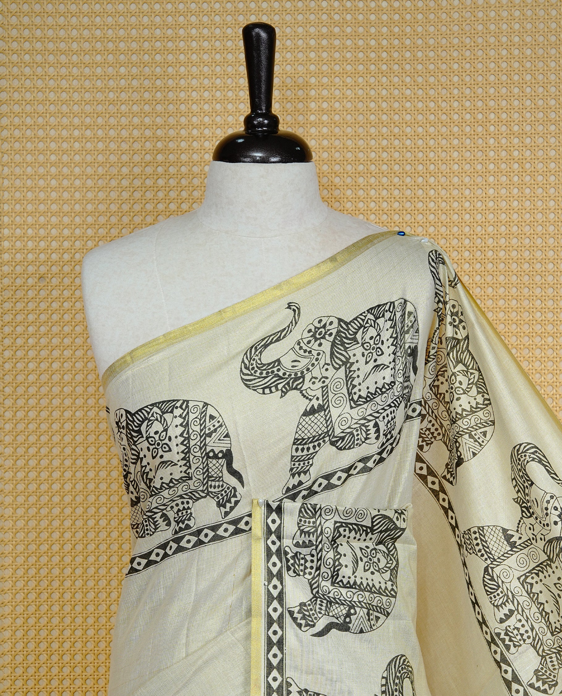 Cream colour Tissue kerala saree featuring Elegant plain body, complemented by Elephant print border, comes with matching blouse piece.