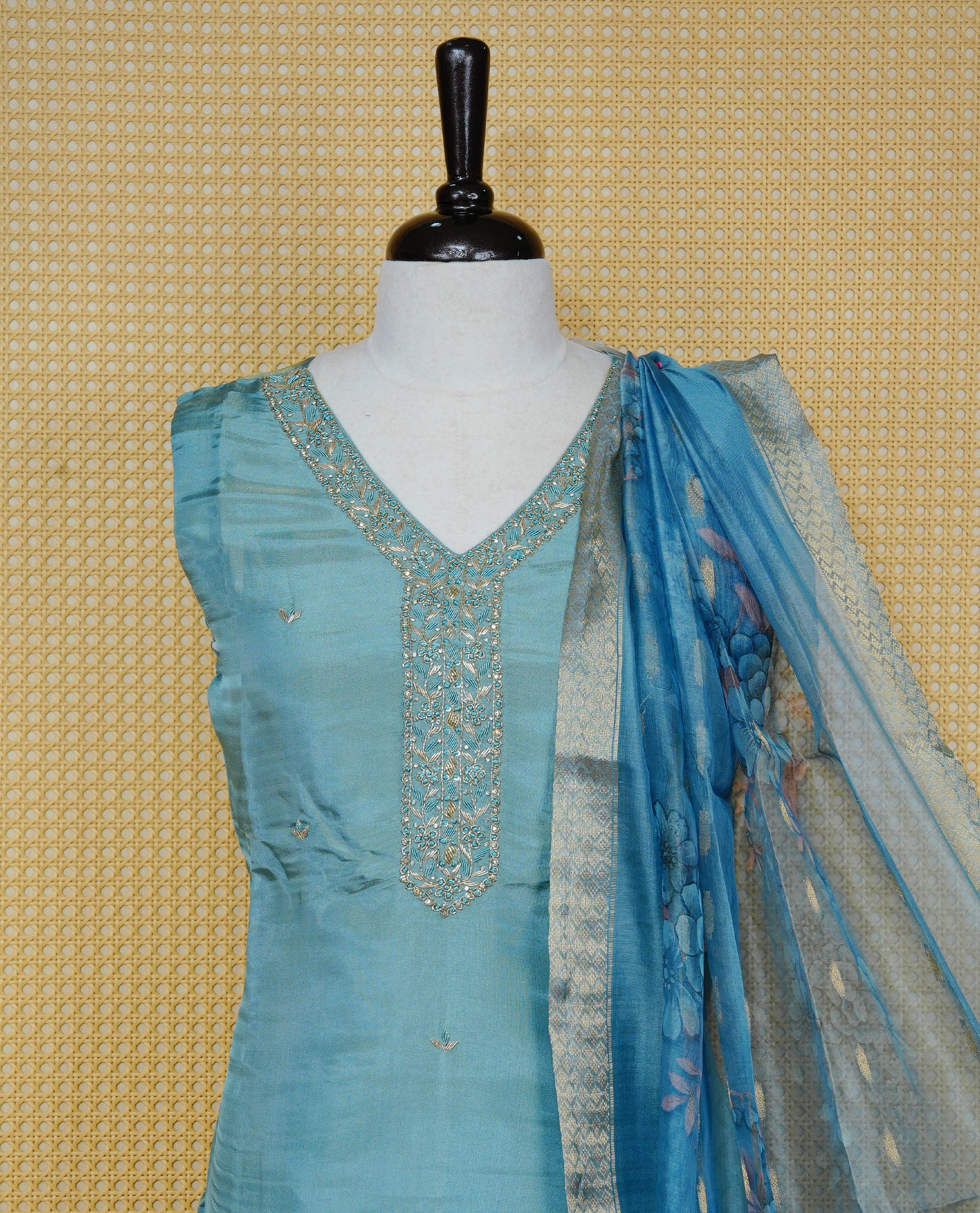 Sky Blue colour churidar set featuring delicate bead & stone Work on the V-neckline, paired with matching solid pants and a floral printed dupatta.