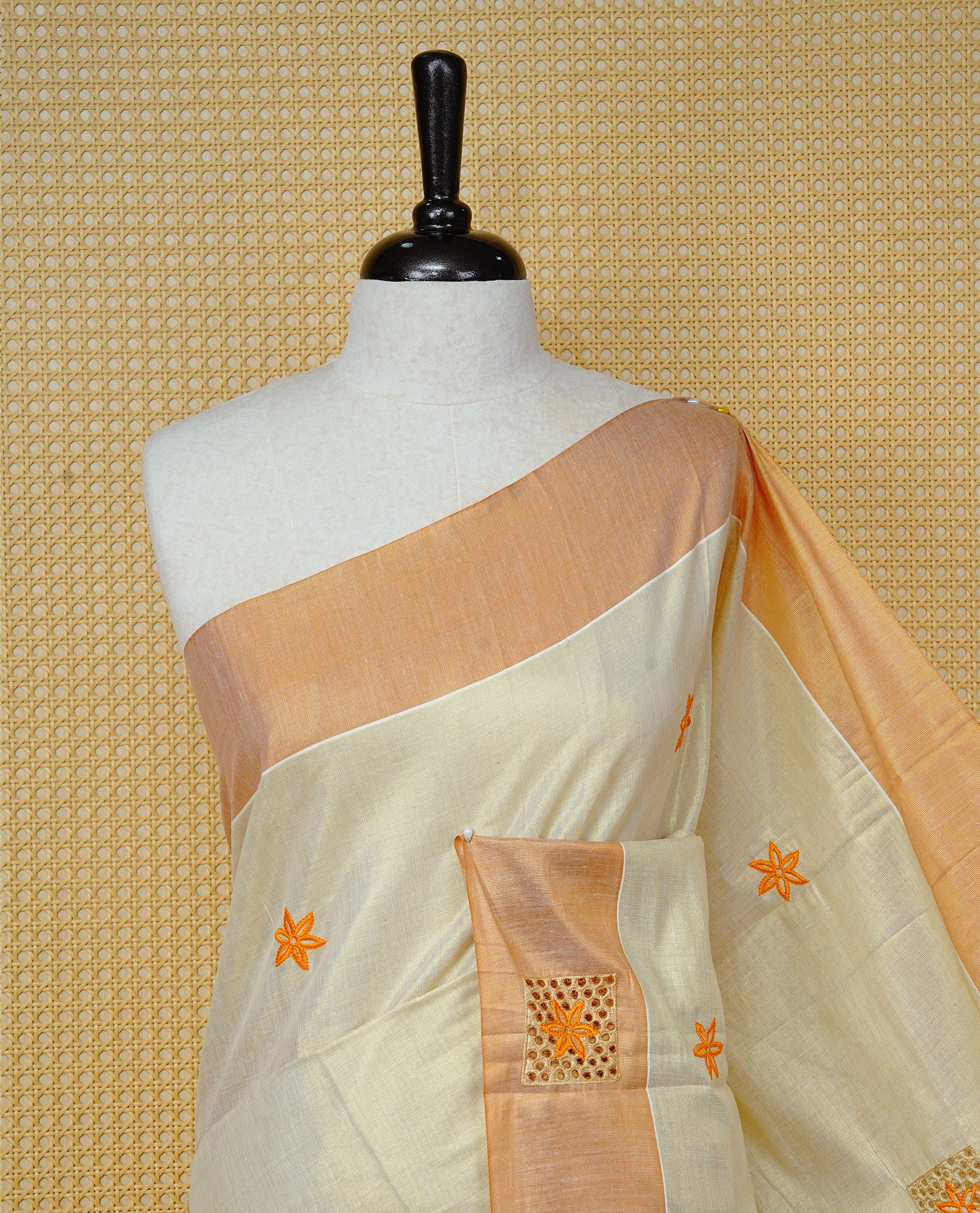 Cream Colour Tissue Kerala Saree Featuring Delicate Orange Floral Emboridery work Across The Body, Enhanced With A Light  Orange Zari Border, A Vibrant Orange And Gold Zari Pallu, Finished With Orange Tassels, And A Matching Blouse Piece
