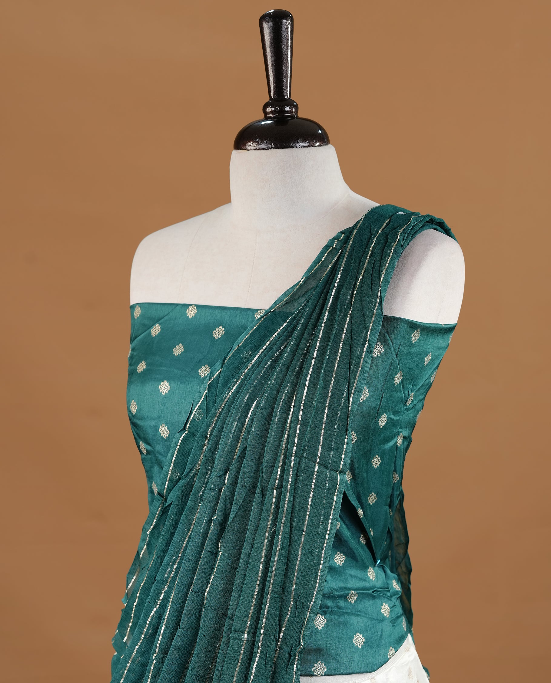 Off white colour semi stitched half saree featuring elegant zari buttas on the body, paired with a contrast green border and matching motifs dupatta,paired with matching blouse piece.