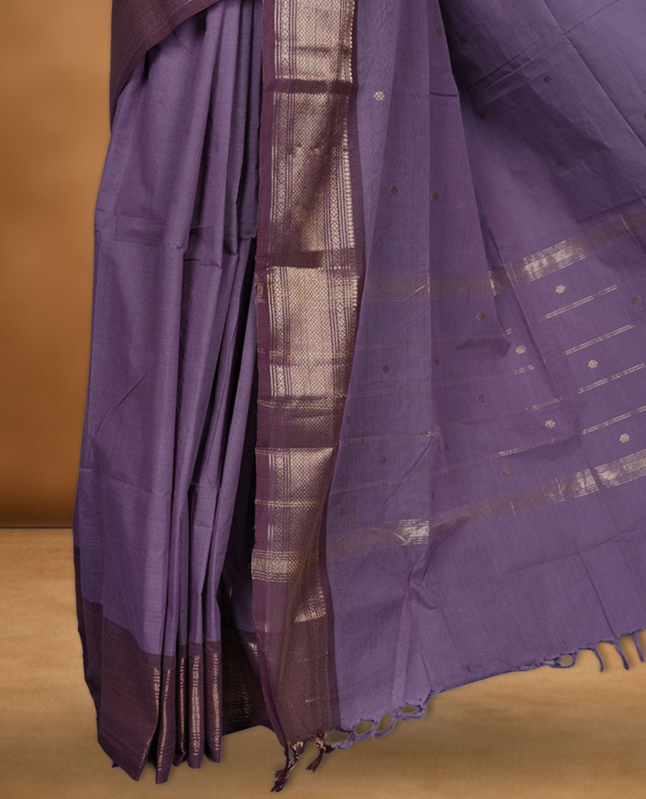 Dark lavender colour chettinad cotton saree featuring small gold zari buttas on body highlighting contrast magenta purple colour with gold zari traditional border, pallu and paired with matching blouse piece.