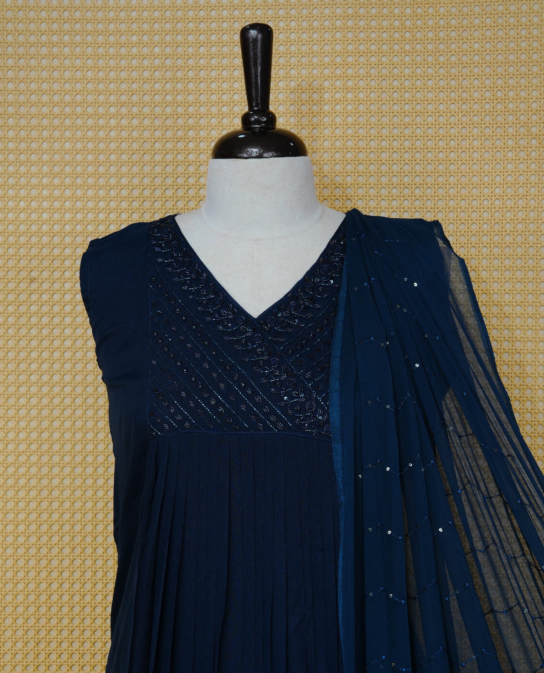 Navy blue churidar set with bead work on the V-neckline, paired with a matching embellished dupatta and solid pants.