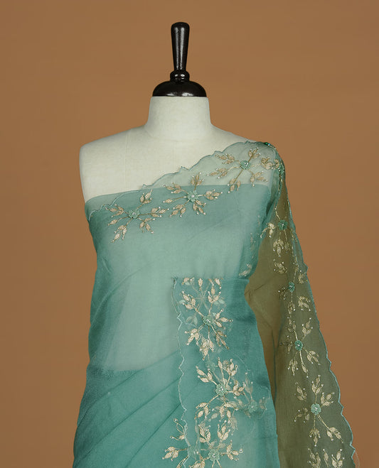 Pastel green colour crush organza saree featuring gold thread floral and stone worked body, highlighting scalp designed border, paired with matching blouse piece.