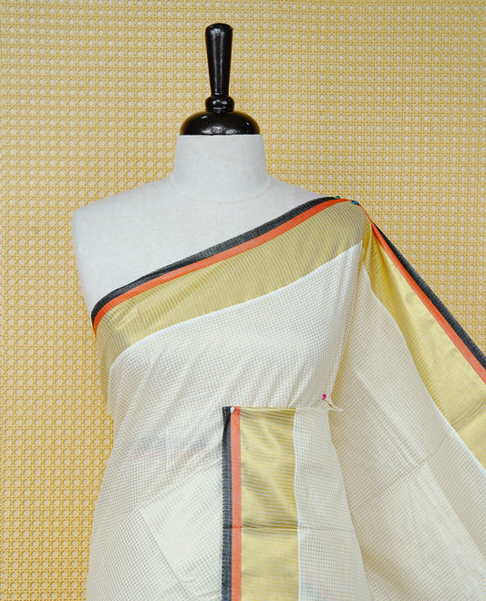 Cream colour cotton Kerala saree Featuring Gold zari Checks across the body, complemented by Classy gold zari with an orange & black Border & pallu, paired with a matching blouse piece.