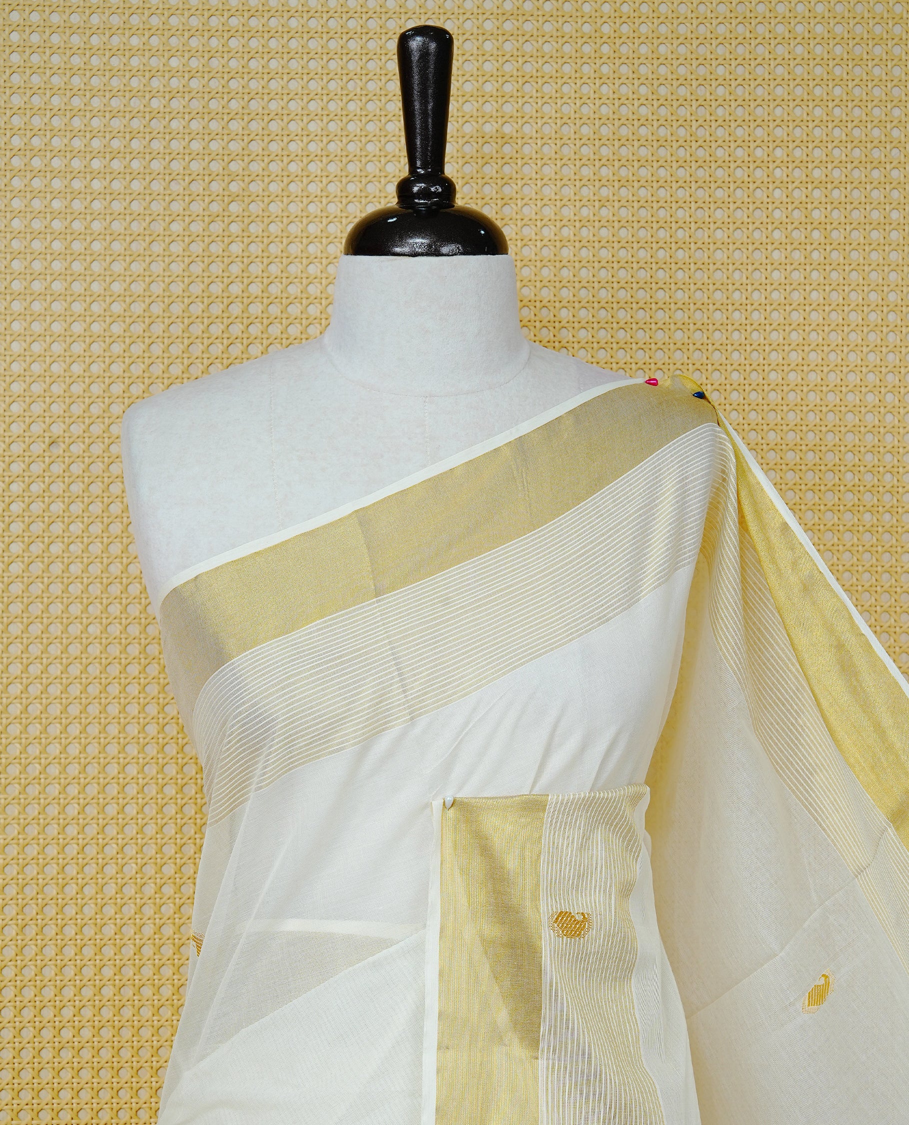 Cream Cotton Colour Kerala Saree Featuring Delicate Gold Mango Motifs, Enhanced with a Rich Gold Zari Border and Fine Striped Detailing. The Elegant Pallu Completes the Traditional Look and Comes with a Matching Blouse Piece.