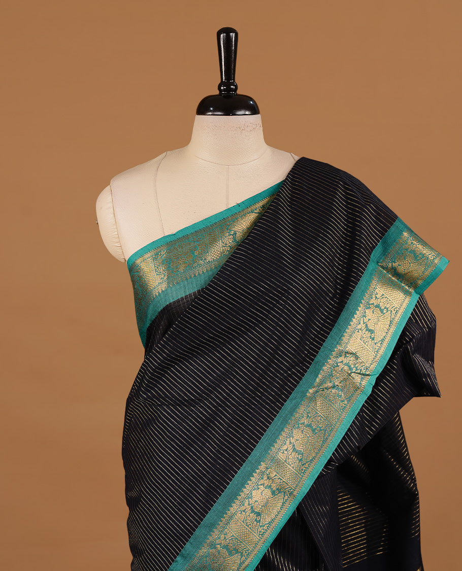 Black colour chettinad cotton saree featuring gold zari stripes on body, complemented by Green colour with zari border, paired with matching blouse piece.