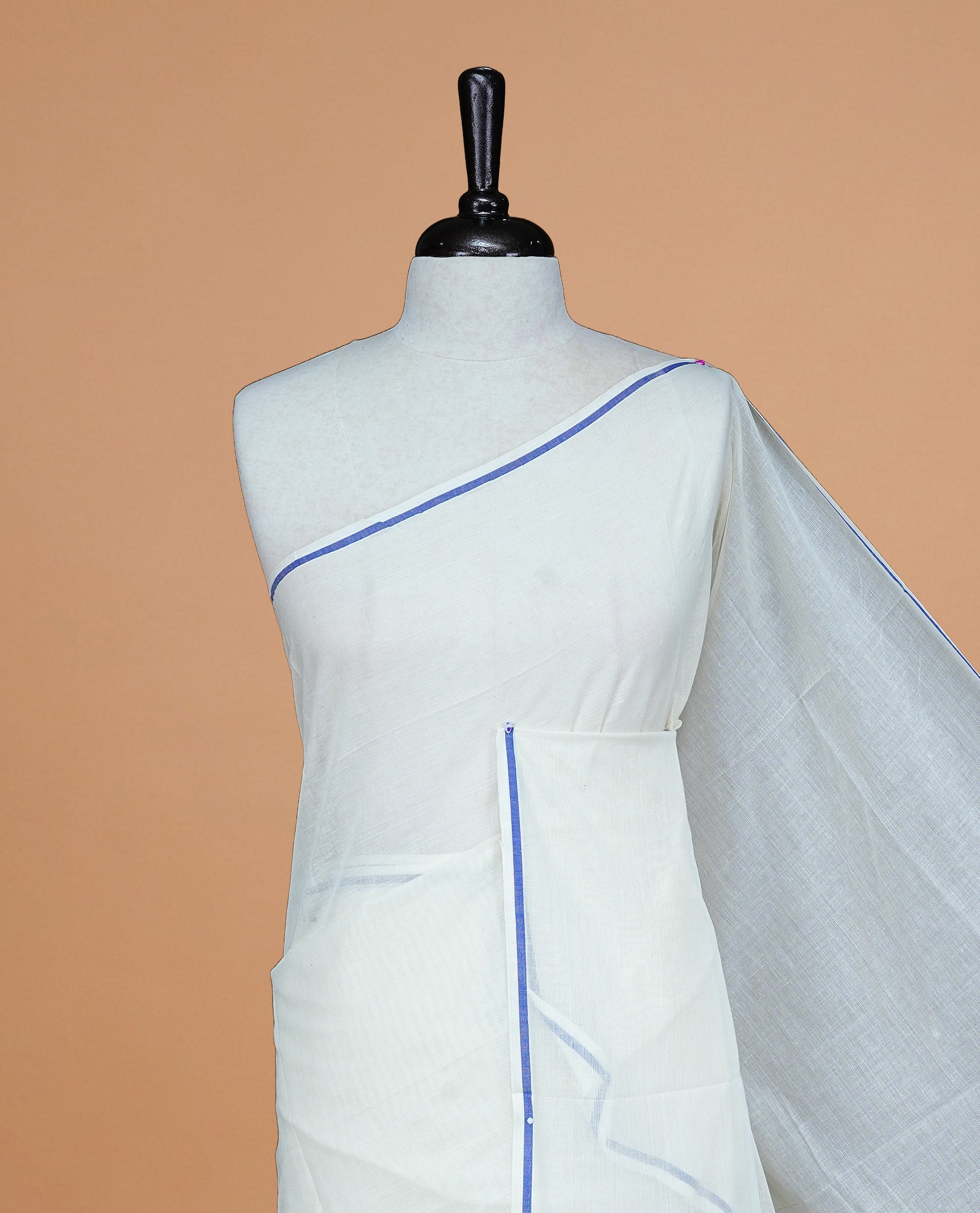 Cream Colour cotton Kerala Saree Featuring A Plain Body, Enhanced By A Minimalistic Blue Border, Paired With A Matching Blouse Piece.