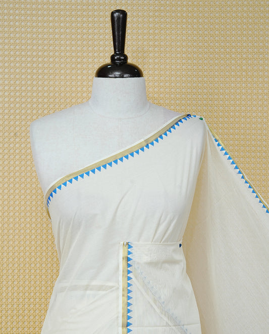 Cream Colour Cotton Kerala Saree Featuring A Gold Zari Border And Blue Temple Edging, Paired With A Matching Blouse Piece