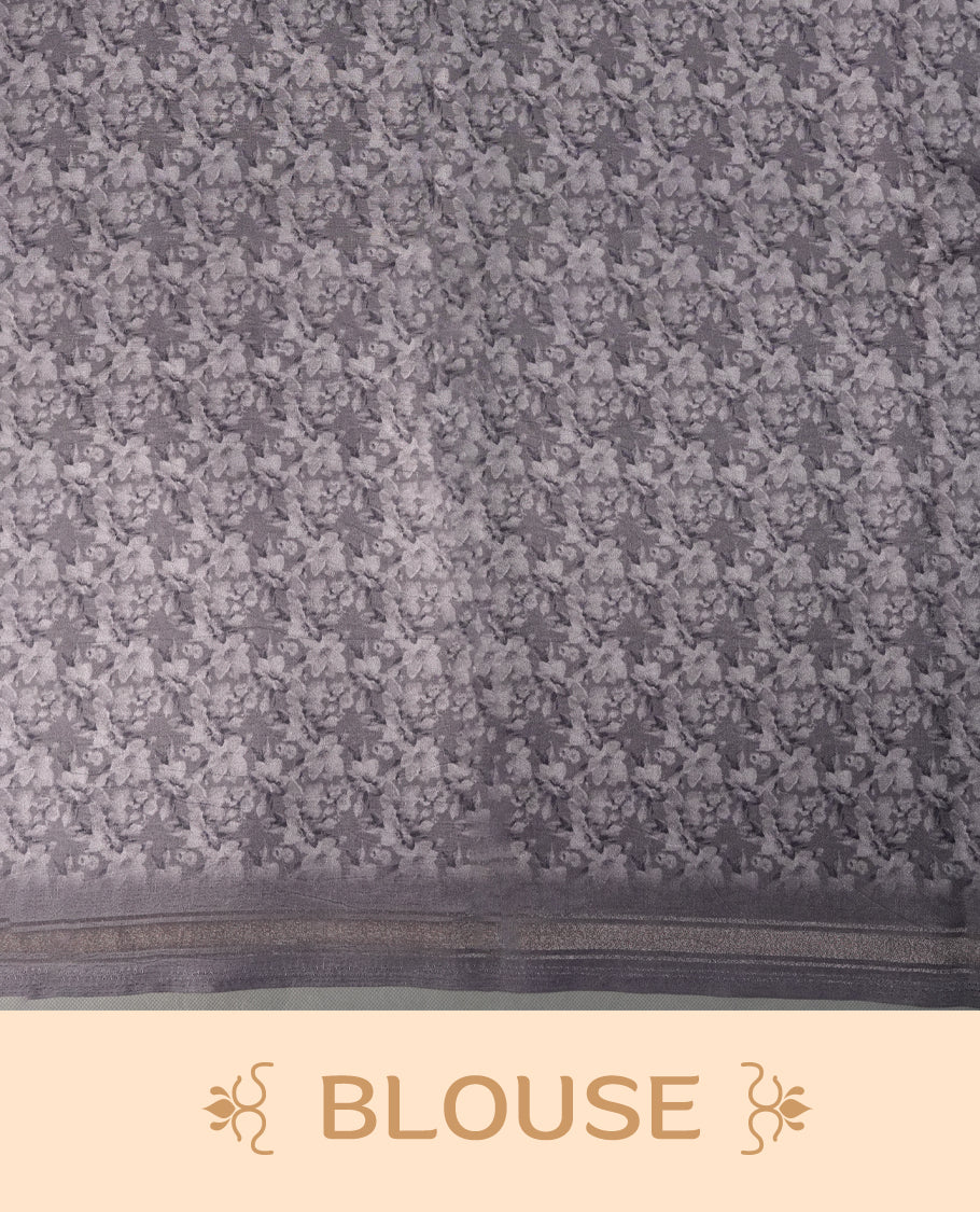 Grey colour  saree adorned with elegant floral prints on the body, enhanced with a subtle matching border, complemented by a beautifully printed pallu featuring blooming flowers, and paired with a matching blouse.