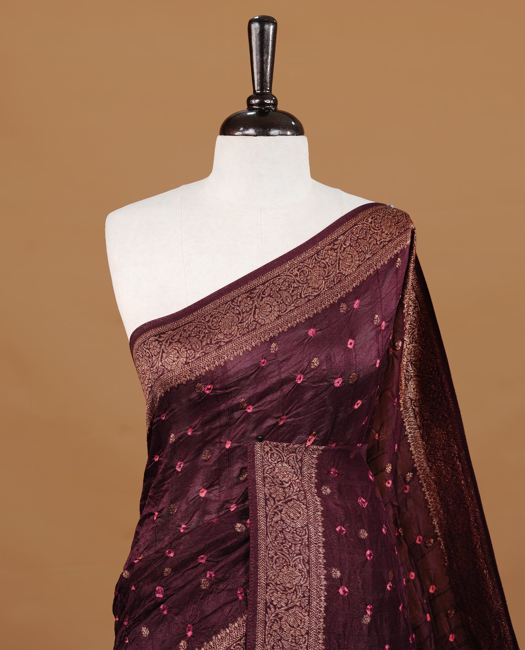 Chocolate brown colour Banarasi Bandhani silk saree featuring intricate antique zari circle Buttas across the body, complemented by an elegant antique zari border. Comes paired with a matching blouse piece