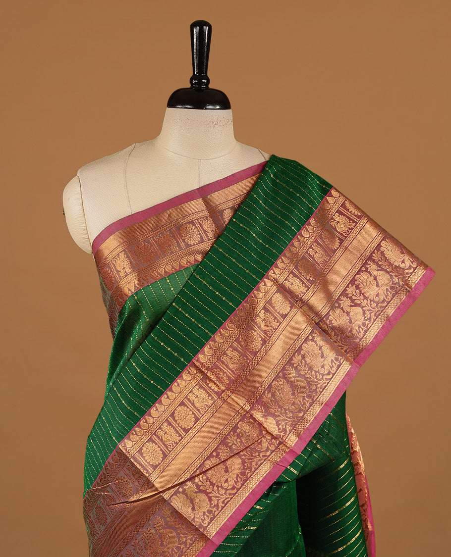 Green colour chettinad cotton saree featuring gold zari stripes on body, complemented by magenta colour with zari border, paired with matching blouse piece.