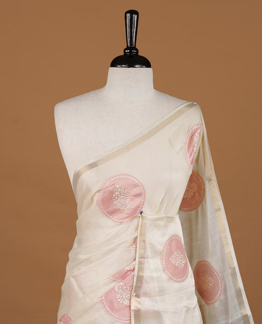 Cream colour Tussar saree featuring pink colour circle pattern with chikankari embroidery work, highlighting gold zari simple border, paired with matching unstitched blouse.