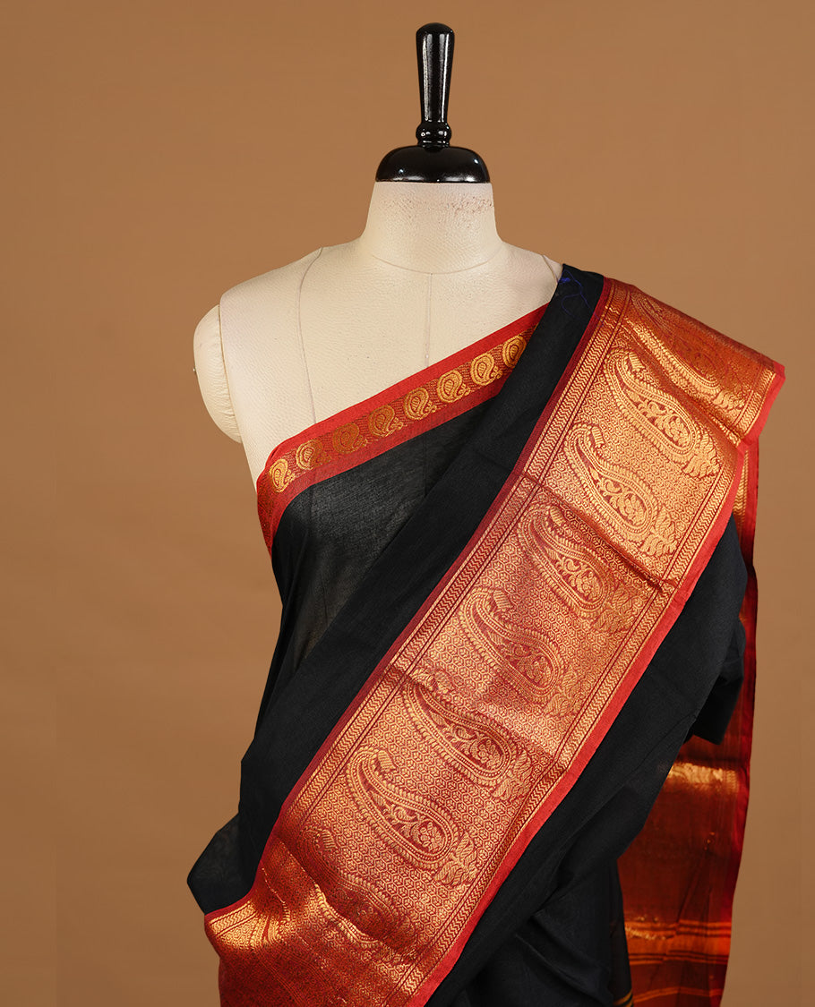 Black colour chettinad cotton saree featuring elegant plain body, complemented by red colour with zari border, paired with matching blouse piece.