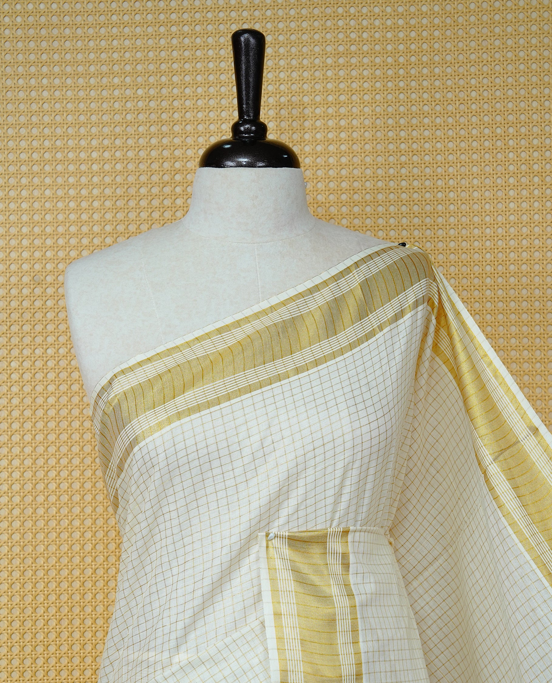 Cream colour Cotton kerala saree featuring Gold zari Checks on body, complemented by Gold zari border & Purple with gold zari on Pallu, paired with matching blouse piece.