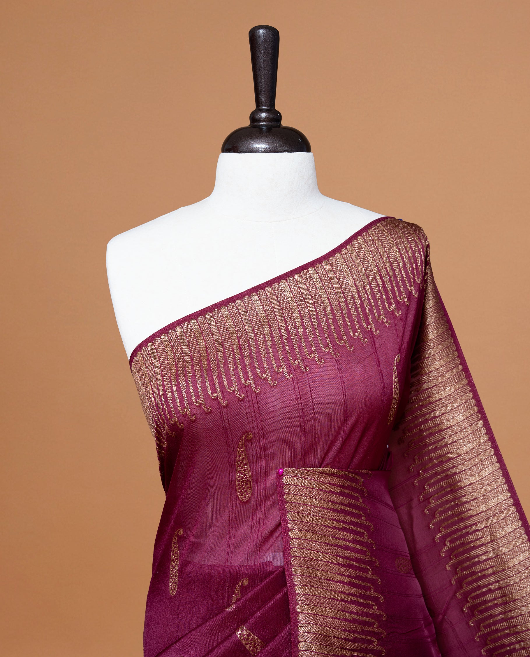 Deep Mauve colour Semi Banaras Tussar Georgette Featuring Gold zari Leaf pattern on body, Finished with Gold zari border and paired with matching blouse piece.