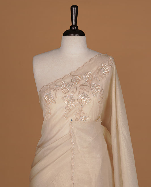 Beige colour net organza saree featuring thread, sequins, cut beats worked on body, highlighting scalp border, paired with matching blouse piece.