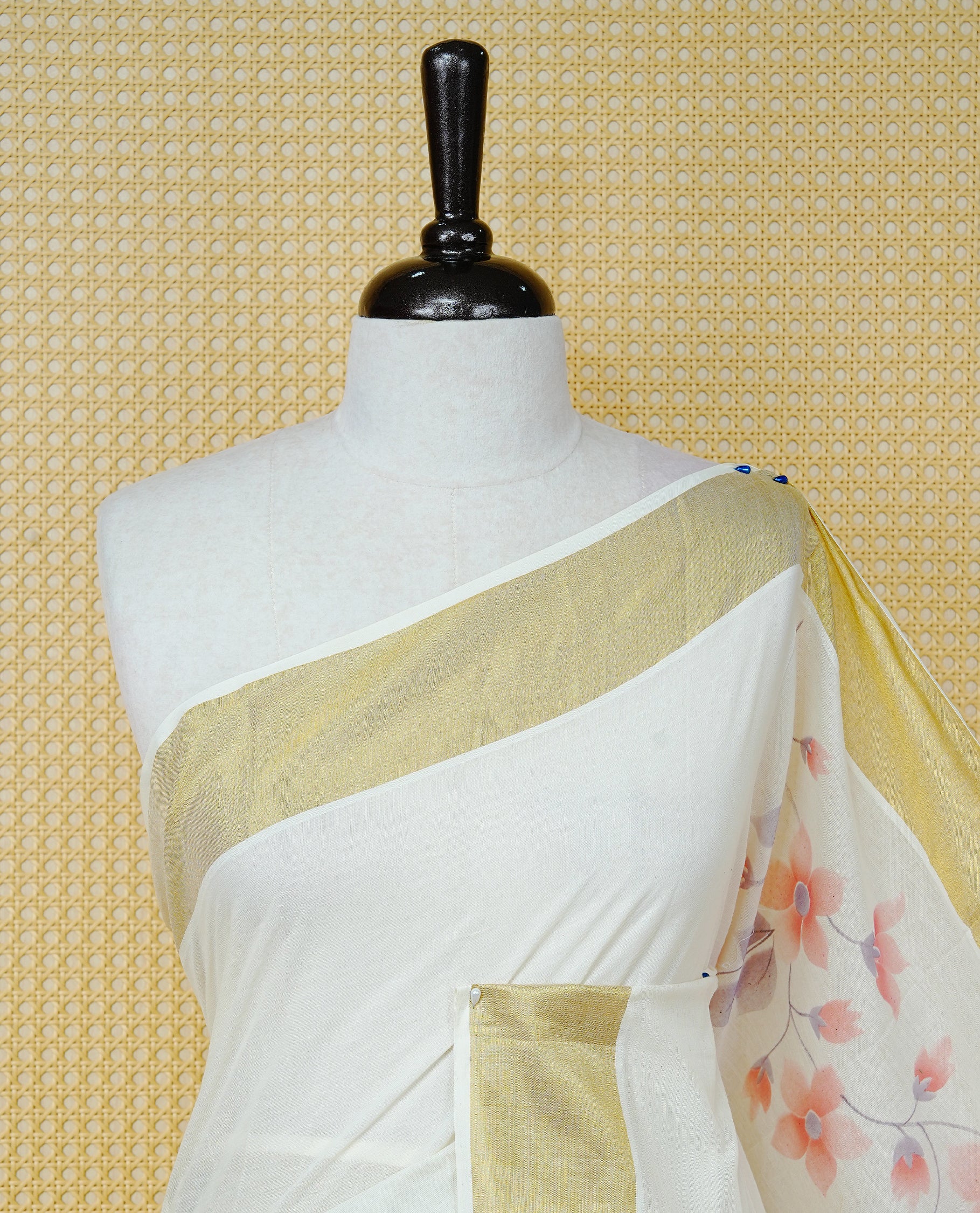 Cream Colour  Cotton Kerala Saree Featuring Digital Floral Prints Across The Body, Enhanced With A Gold Zari Border, Traditional Gold Zari Pallu, Finished With Peach & White  Tassels And A Matching Blouse Piece.