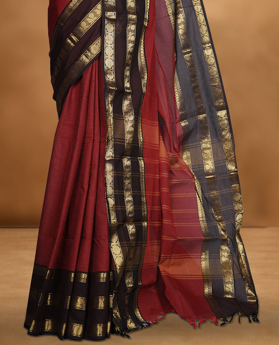 Red colour chettinad cotton saree featuring plain body, contrast chocolate brown colour with traditional gold zari border paired with matching blouse.