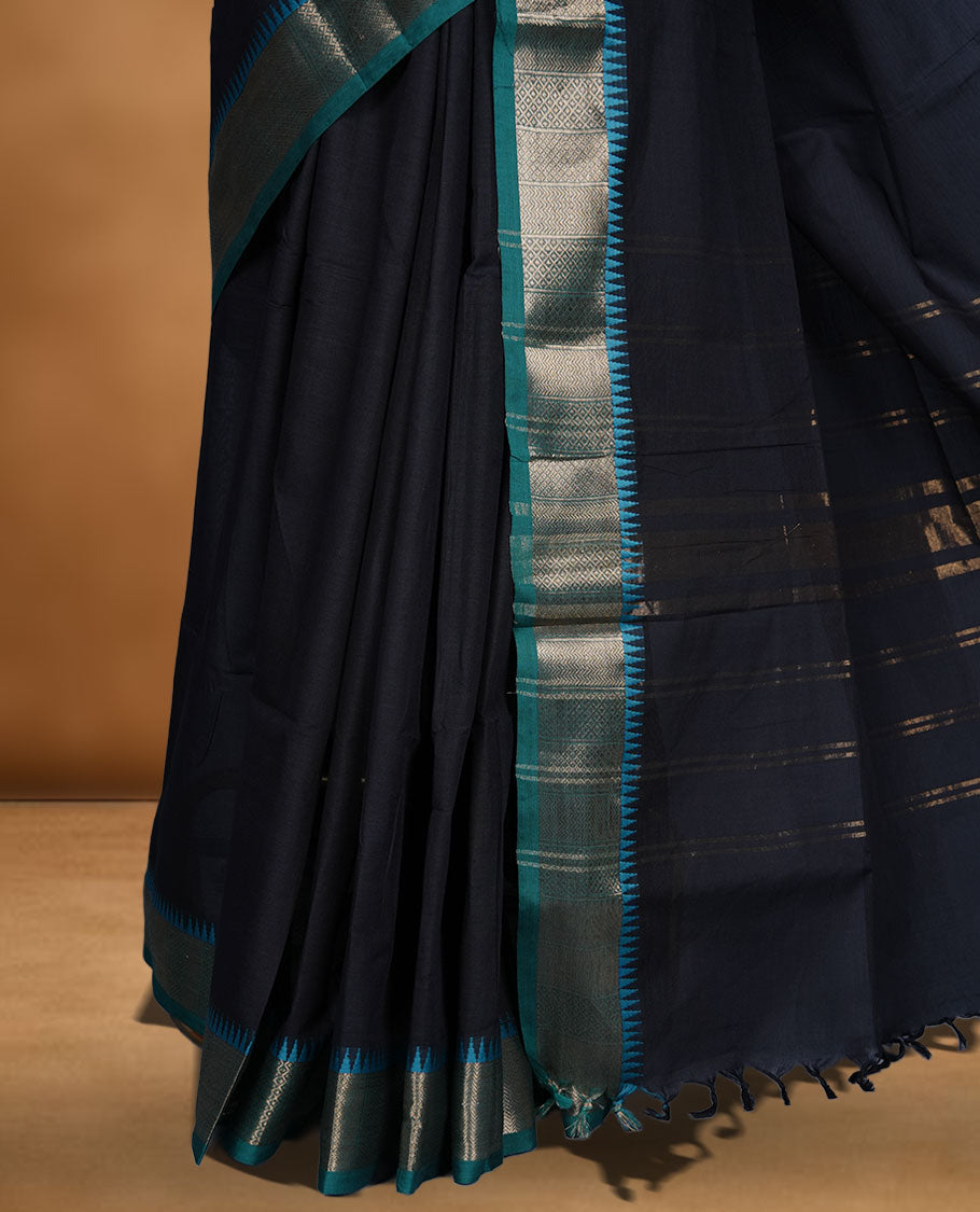 Black colour chettinad cotton saree featuring Elegant plain body highlighting contrast green colour colour with gold zari traditional border, pallu and paired with matching blouse piece.