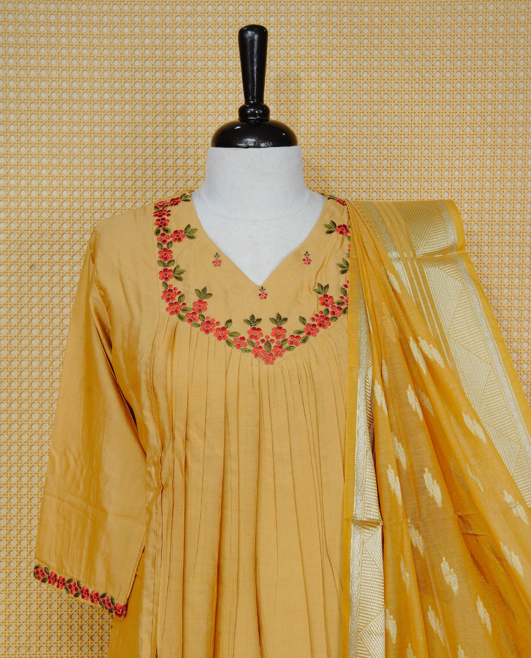 Mustard yellow colour churidar set with floral thread embroidery along the V-neckline and sleeve cuffs, pleated detailing on the front, paired with a matching dupatta and solid pants.