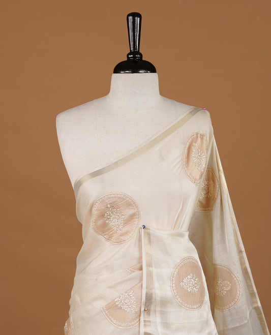 Cream colour Tussar saree featuring gold colour circle pattern with chikankari embroidery work, highlighting gold zari simple border, paired with matching unstitched blouse.