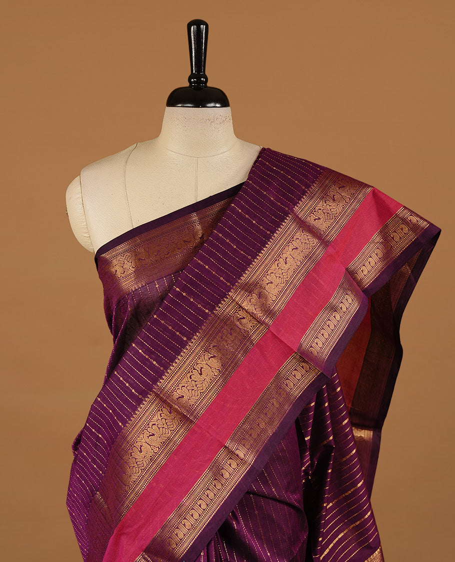 Purple colour chettinad cotton saree featuring gold zari motifs on body, complemented by magenta colour with zari border, paired with matching blouse piece.