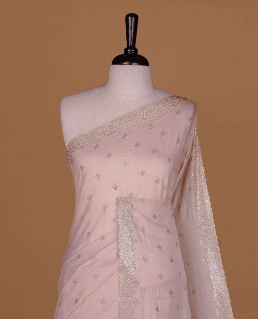 Light peach colour organza designer saree featuring Gold stone motifs on body, highlighting light weight stone worked border, paired with matching blouse piece.