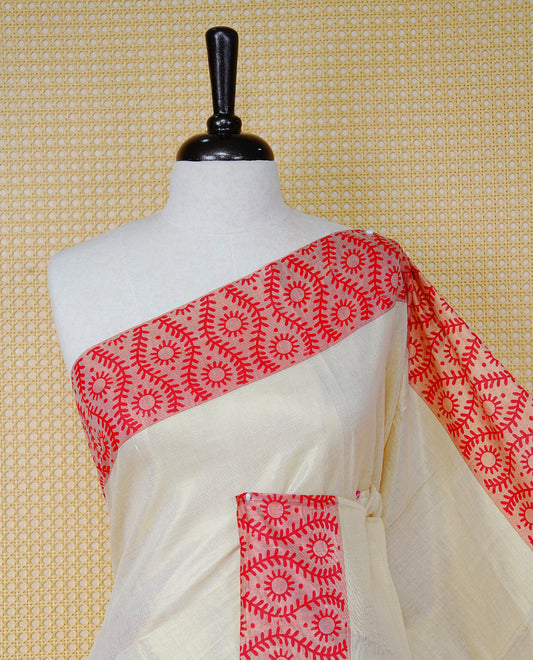 Cream Colour Tissue Kerala Saree Featuring a Plain Body, Enhanced with Red Block  Printed Borders, a Red and Gold Zari Pallu, Red Tassels, and a Matching Blouse Piece.