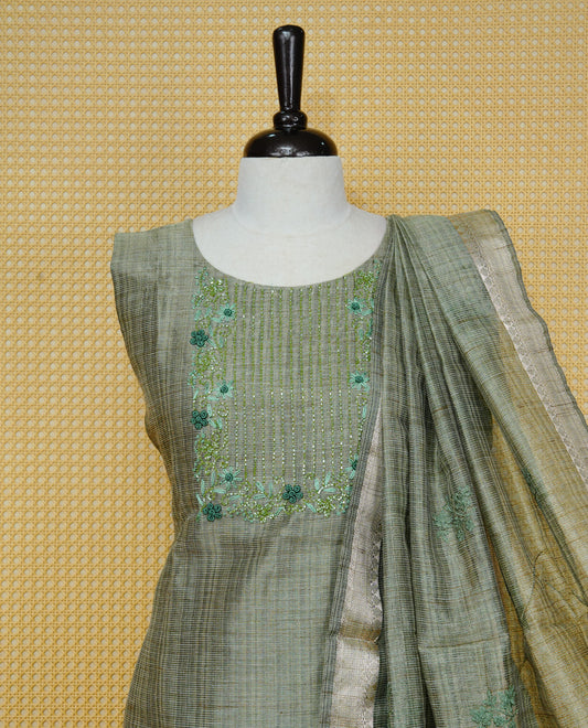 Green colour Tissue Churidar Set featuring delicate floral embroidery and subtle sequin detailing on the yoke, paired with matching solid pants and dupatta.