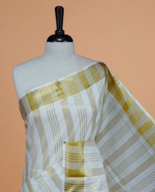 Cream Colour Cotton Kerala Saree Featuring Gold zari stripes On The Body & Classy Gold zari border, Paired With A Matching Blouse Piece.