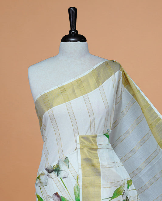Cream Colour Cotton Kerala Saree Featuring Gold Zari Strips & Floral Printed  Body, Enriched By A Light Gold Zari Border, Paired With A Matching Blouse Piece.