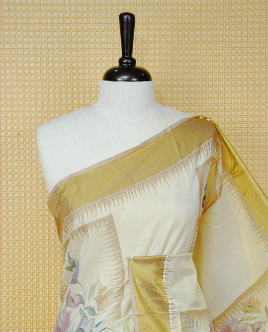 Cream Colour Tissue Kerala Saree Featuring Soft Floral Prints in a Classic Rectangle Pattern On Body, Enhanced with a Rich Gold Zari Border and a Striped Pallu. Finished with Elegant Tassels and Paired with a Matching Blouse Piece.
