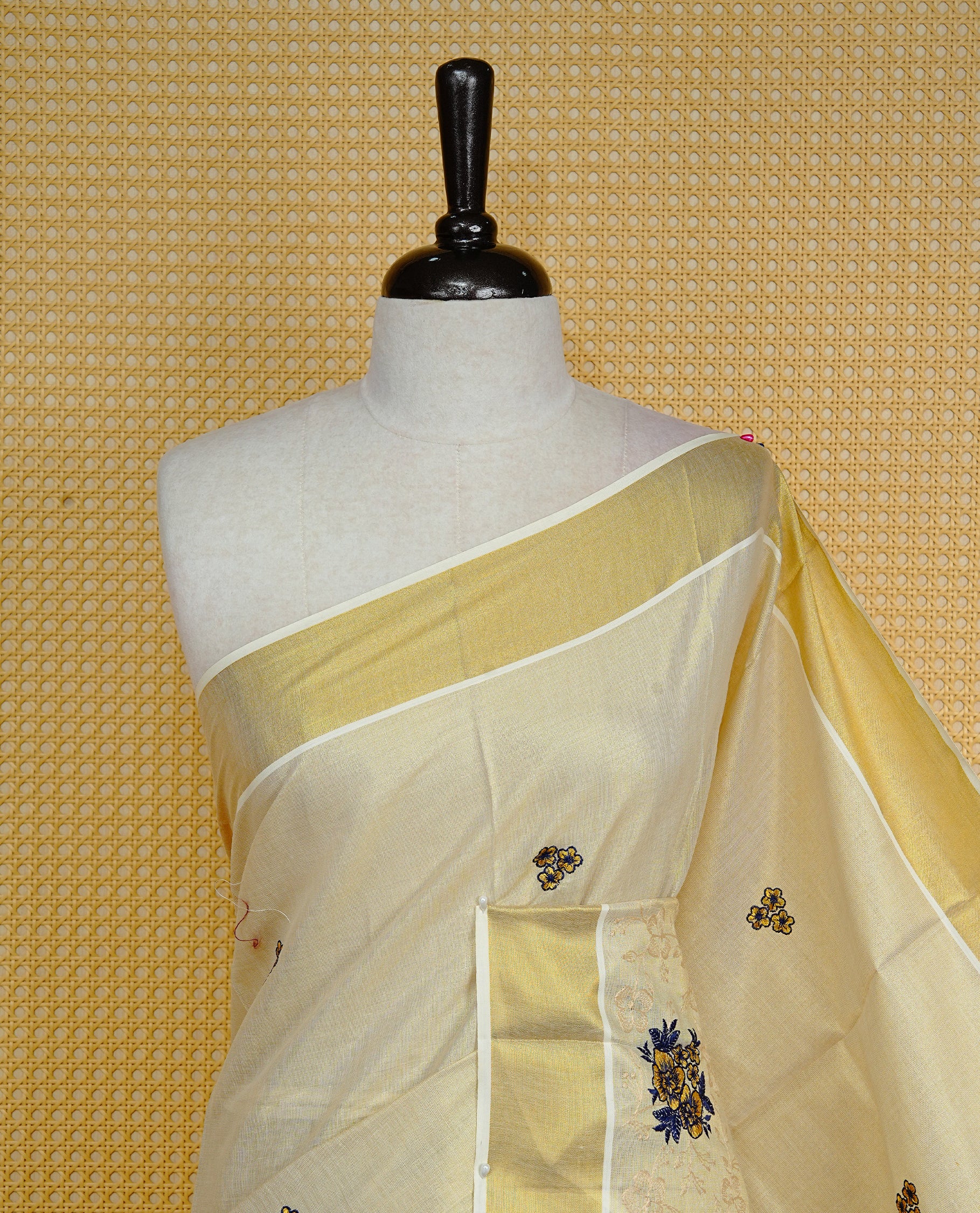 Cream colour Tissue kerala saree featuring Embroidery buttas on body, complemented by Floral kodi thread work & kasavu kara, comes with matching blouse piece.