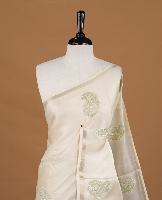Cream colour Tussar saree featuring Light green colour Mango pattern with chikankari embroidery work, highlighting gold zari simple border, paired with matching unstitched blouse.