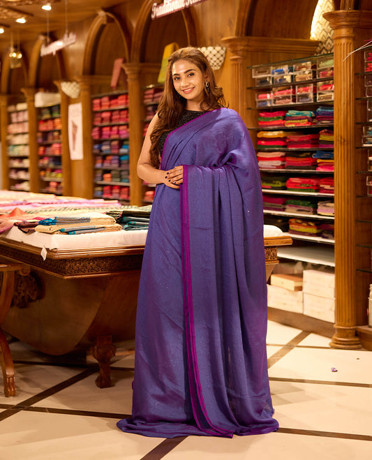 Purple colour viscose saree in rich teal shade featuring a subtle sheen and lightweight drape, enhanced with satin piping finished border, paired with a matching blouse piece