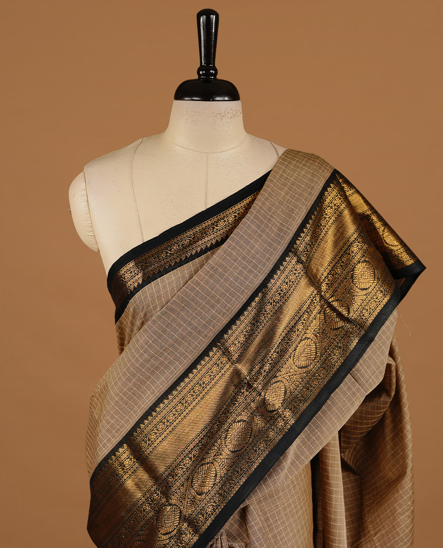 Cream tan colour chettinad cotton saree featuring gold zari motifs on body, complemented by Black colour with zari border, paired with matching blouse piece.