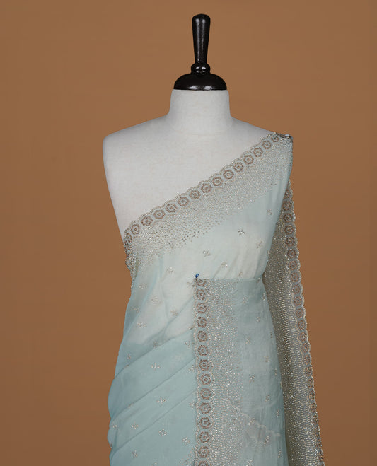 Mint colour designer saree featuring gold & white stone worked body and border, paired with matching blouse piece.