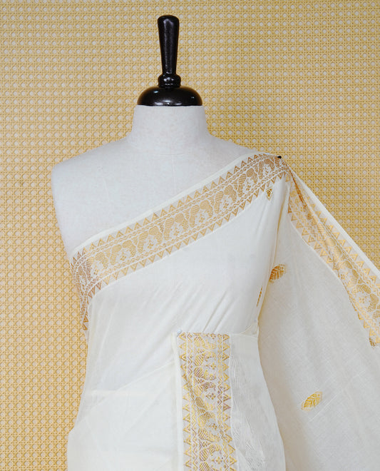 Cream Colour Cotton Kerala Saree Featuring Gold Buttas on the Body, a Classy Gold Zari Border, and a Traditional Violet Colour Lord Krishna Thread work and Gold Zari Pallu, Paired with a Matching Blouse Piece.